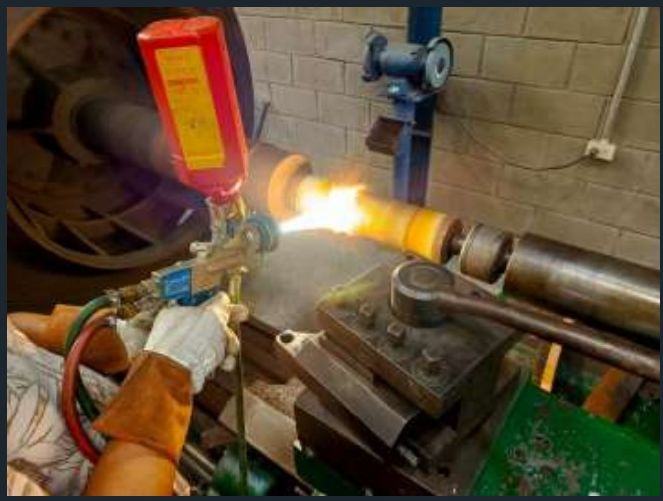 Aplicación de proyección térmica HVOF sobre eje montado en torno