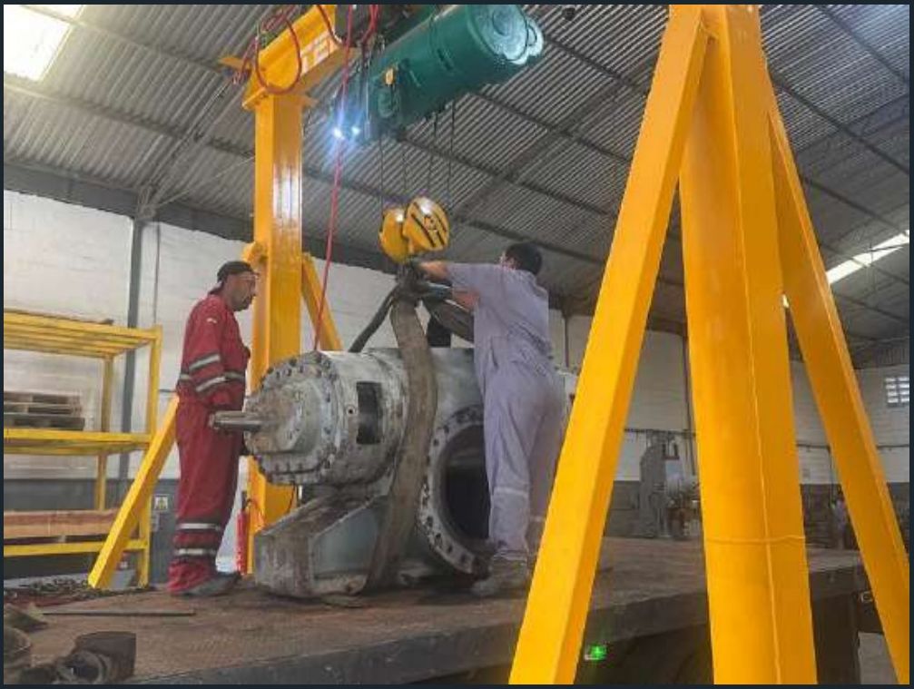 Izamiento de carcasa de bomba con grúa pórtico en el taller